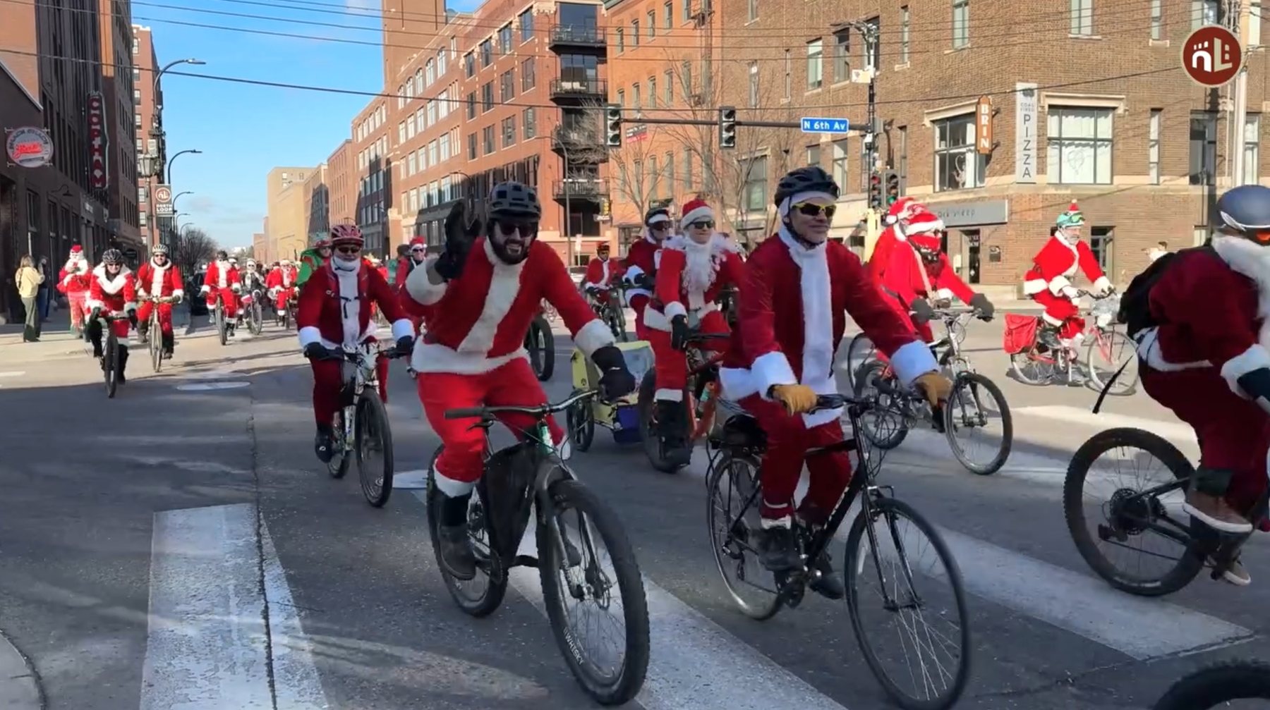 A large group of Santa-costumed cyclists riding through Minneapolis