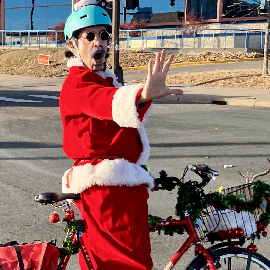 A Santa rider posing beside a decorated bicycle